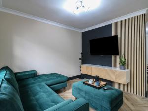 een woonkamer met een groene bank en een televisie bij Seibiant in Ramsgate