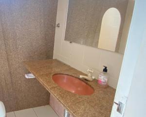 a bathroom with a red sink and a mirror at FRENTE MAR CASTELHANOS Casa Recanto Azul 7 Suítes Lazer Completo e Conforto recém reformada para Até 25 Pessoas Ideal para reunir Famílias e Amigos in Anchieta