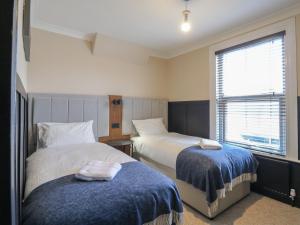 een slaapkamer met twee bedden en een raam bij Seibiant in Ramsgate