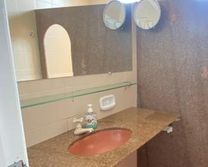 a bathroom with a red sink and a mirror at FRENTE MAR CASTELHANOS Casa Recanto Azul 7 Suítes Lazer Completo e Conforto recém reformada para Até 25 Pessoas Ideal para reunir Famílias e Amigos in Anchieta +39 photos