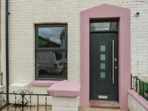 een huis met een zwarte deur en twee ramen bij Seibiant in Ramsgate