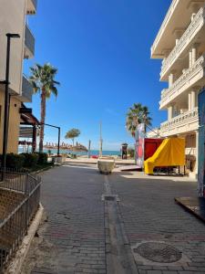 an empty street with palm trees and the ocean at Beach Home Retreat in Durrës +7 photos