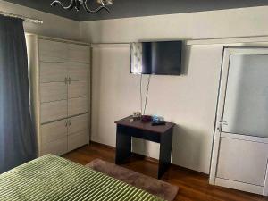 a bedroom with a table and a bed and a cabinet at Salcia Riverside Apartment in Galaţi