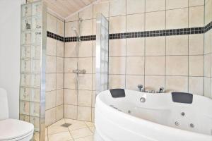 a bathroom with a white tub and a toilet at 30006-Malling-Laerkevaenget-8 in Malling +18 photos