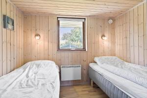 a room with two beds in a wooden room with a window at 30006-Malling-Laerkevaenget-8 in Malling