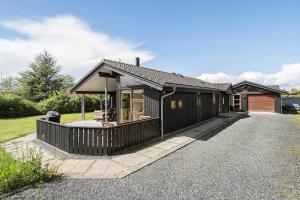 a black house with a patio and a house at 30006-Malling-Laerkevaenget-8 in Malling
