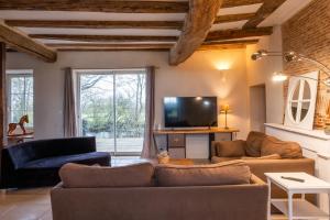 un salon avec un canapé et une télévision dans l'établissement gîte de la La Haute Boulière, à Saint-Herblon