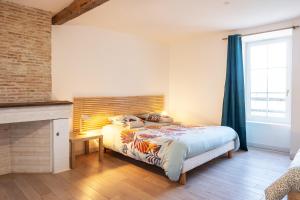 une chambre avec un lit avec une tête de lit en bois dans l'établissement gîte de la La Haute Boulière, à Saint-Herblon