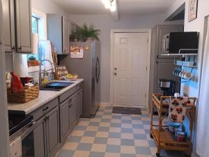 a kitchen with a refrigerator and a checkered floor at Winter Escape Pet Friendly Cottage with Jacuzzi Tub and Reading Nook in Pensacola