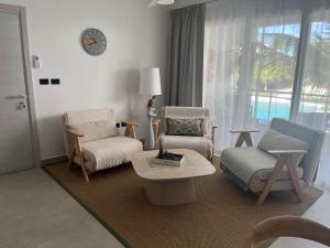 a living room with chairs and a table and a clock at Estrella Izha 204 in La Laguna +20 photos