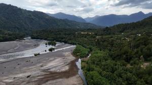 eine Luftansicht auf einen Fluss mit Bergen im Hintergrund in der Unterkunft Camping Patagonfox in Los Ladrillos