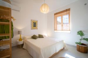 een witte slaapkamer met een bed en een raam bij Villa Serenità - with private pool and ocean view in Ricadi +40 foto's