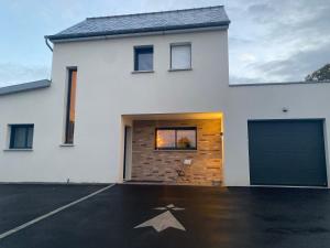 Montauban-de-BretagneにあるChambre privé à deux pas de la gareの白い矢印が付いたガレージ付きの白い家