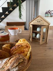 a table with a basket of bread and a bird house at Chambre privé proche gare V électrique in Montauban-de-Bretagne