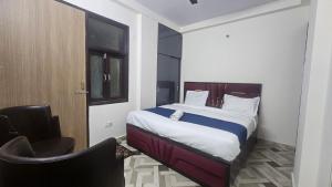 een slaapkamer met een bed en een stoel erin bij Hotel Glass Castle Near Yashobhoomi in New Delhi