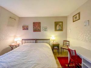 a bedroom with a bed and a desk and two chairs at La Clé de Marc in Le Vésinet