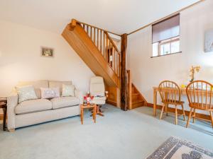 a living room with a couch and a staircase at The Cottage - Uk45459 in Loftus