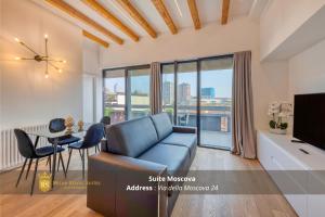 a living room with a couch and a table with a television at Milan Royal Suites - Centro in Milan