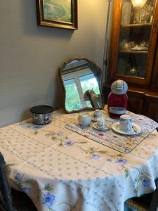 una mesa con mantel y un espejo en CHAMBRE CHEZ L'HABITANT NOISIEL, en Noisiel