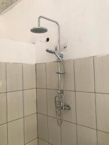 a shower in a bathroom with a shower head at Jambo Guest House in Taba