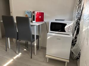 a microwave sitting on top of a table with two chairs at RoomsCarli in Comacchio