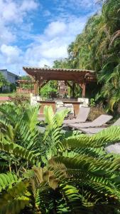a patio with two chairs and a wooden pergola at Hacienda El Palmar A in Vega Baja