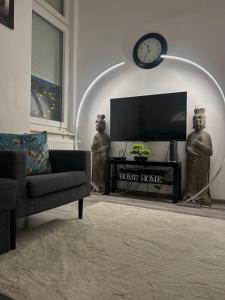 een woonkamer met een tv en een bank en een klok bij Palace Residence in Boedapest