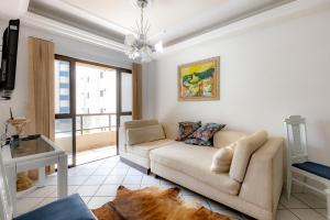 a living room with a couch and a window at Apartamento com Varanda, Churrasqueira e Vista Mar in Meia Praia