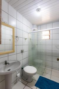 a bathroom with a sink and a toilet and a mirror at Apartamento com Varanda, Churrasqueira e Vista Mar in Meia Praia +20 photos