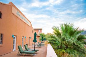 een groep stoelen en parasols buiten een gebouw bij Sierra Grande, a Ted Turner Retreat in Truth or Consequences