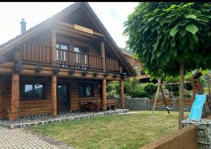 ミート・ポッド・ドゥンビエロムにあるZrub EMMAのバルコニー付きの大きな木造家屋