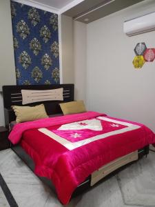 a bedroom with a large bed with a red blanket at The Starlight Farm- Poolside Tent Stay in Jaipur in Jāmb