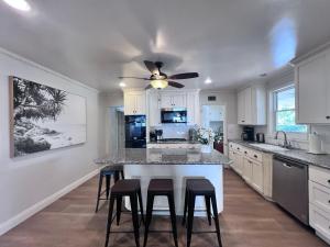 a kitchen with a ceiling fan and a kitchen island with stools at Destination #13 in Anaheim
