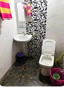 a bathroom with a white toilet and a sink at The Starlight Farm- Poolside Tent Stay in Jaipur in Jāmb