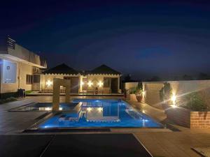 a swimming pool in front of a house at night at The Starlight Farm- Poolside Tent Stay in Jaipur in Jāmb +10 photos