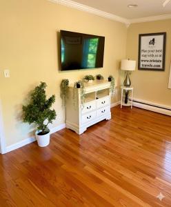a living room with a television and a wooden floor at Forest and River Side Tranquil House in Montague +30 photos