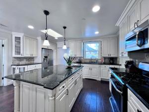 a kitchen with white cabinets and a black counter top at Destination #22 in Anaheim