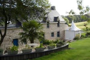 a stone house with plants in front of it at A L'abri in Saint-Nolff
