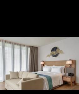 a hotel room with a bed and a couch at Marianna Resort & Convention Tuktuk - Samosir, Marclan Collection in Ambarita