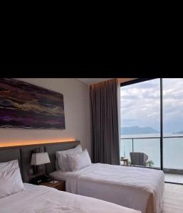 a hotel room with two beds and a large window at Marianna Resort & Convention Tuktuk - Samosir, Marclan Collection in Ambarita