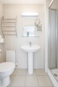 a white bathroom with a sink and a toilet at 3 Bed Spacious House in Castletroy, Limerick 
