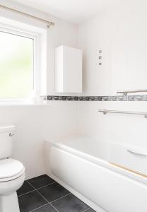 a white bathroom with a tub and a toilet at 3 Bed Spacious House in Castletroy, Limerick  +4 photos