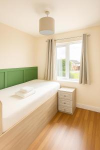 a bedroom with a large bed and a window at 3 Bed Spacious House in Castletroy, Limerick 