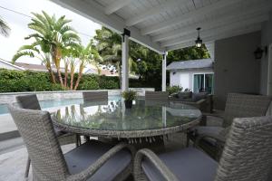 a patio with a glass table and chairs and a pool at Destination #39 in Orange