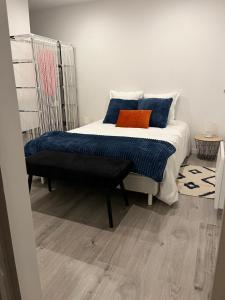 een slaapkamer met een bed met blauwe en oranje kussens bij Violette 2 in La Souterraine