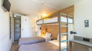 a small room with two bunk beds and a tv at Premiere Classe Versailles - Saint Cyr L'ecole in Saint-Cyr-lʼÉcole +19 photos
