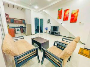 a living room with two chairs and a table at Downsouth Cabanas in Habaraduwa