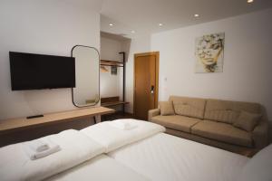 a living room with a bed and a couch at Calma Experience in Korçë