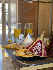 a table with a plate of food and glasses of orange juice at M Résidence Marrakech Luxury Serviced Apartments in Marrakesh