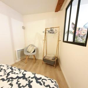 ein Schlafzimmer mit einem Bett, einem Stuhl und einem Fenster in der Unterkunft Appartement Saint Martin in Ussel